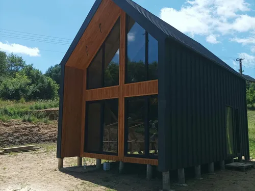 Boczny widok domu w stylu stodoły z przeszkloną ścianą szczytową