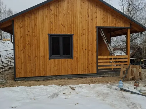 Front domu drewnianego z oknem i werandą, ujęcie z przodu