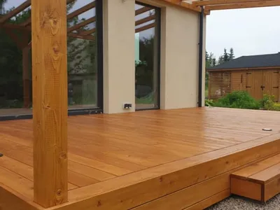 Pergola wsparta na drewnianym słupie przy elewacji domu w Brzozowie